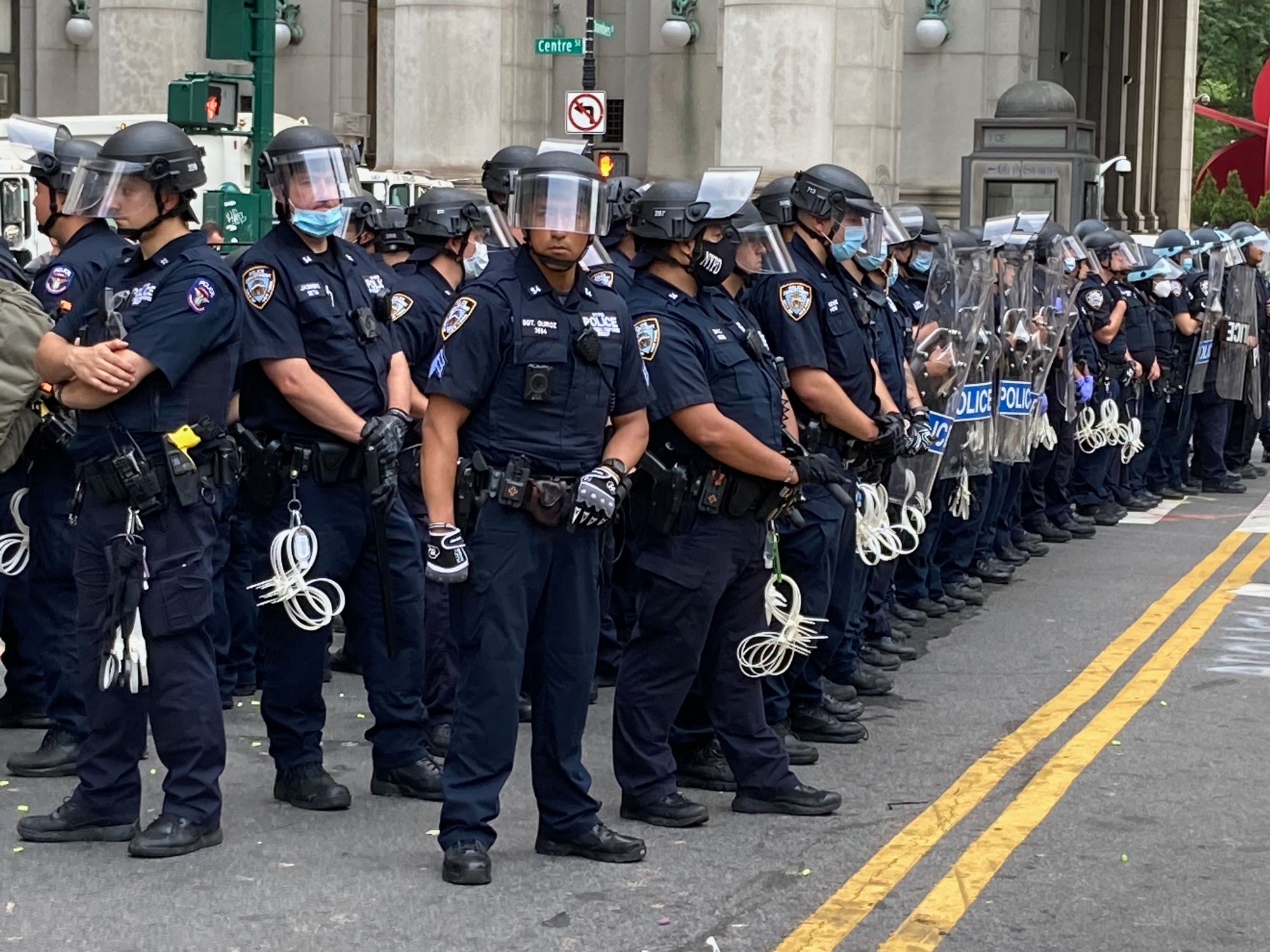 Police officers in riot gear lined up along a street in Lower Manhattan.