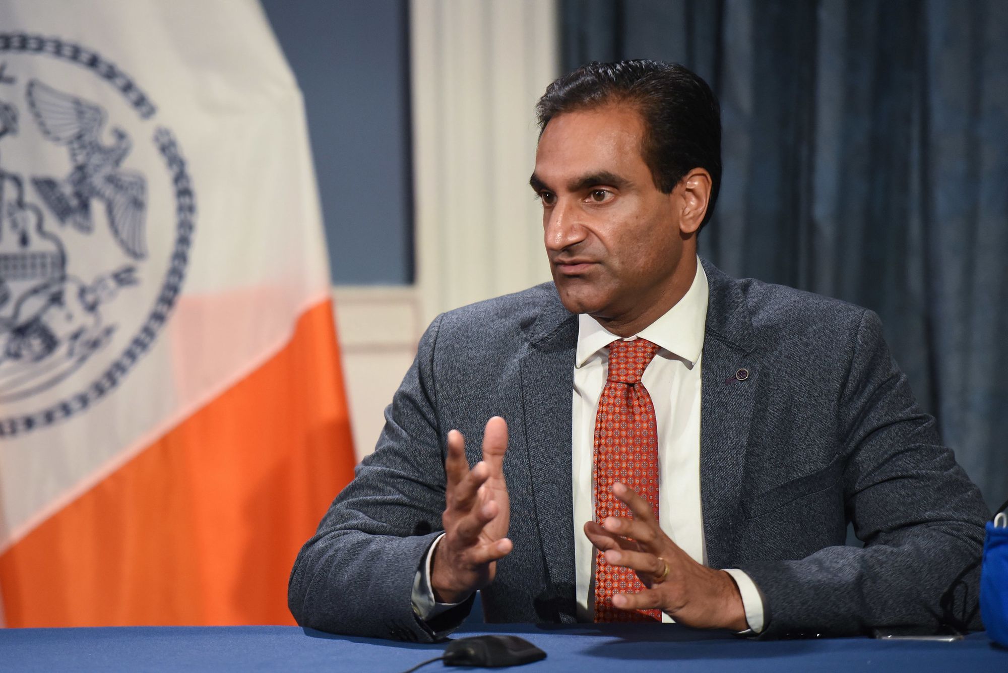Dr. Jay Varma sitting at a table at City Hall.