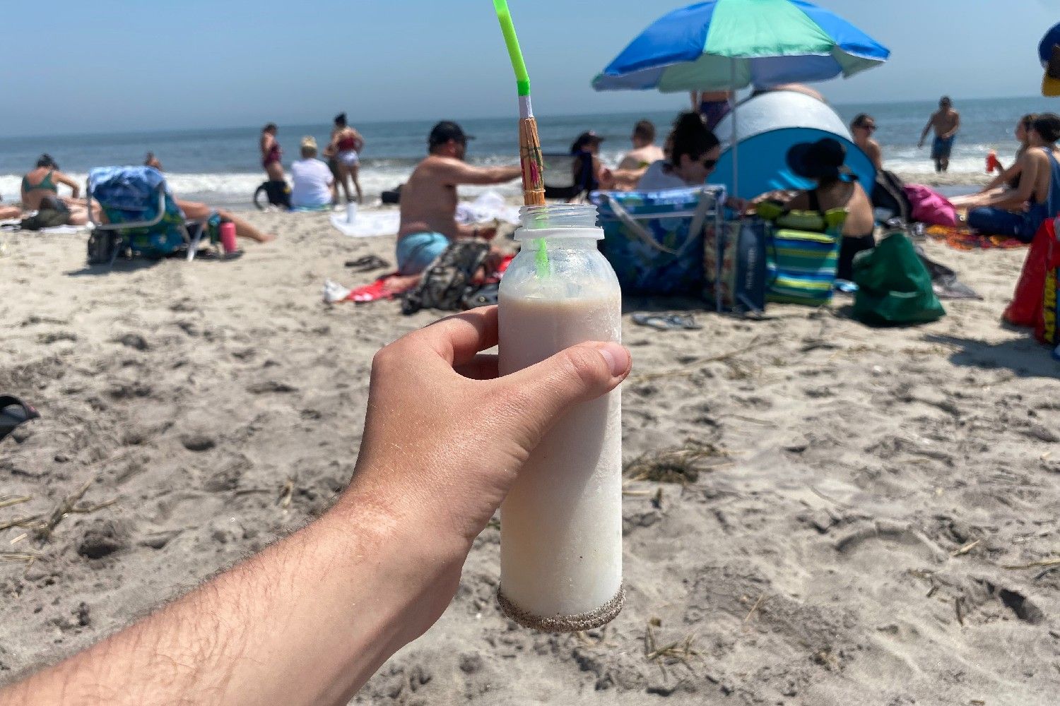 A person holding a nutcracker up with a view of the beach and ocean in the background.