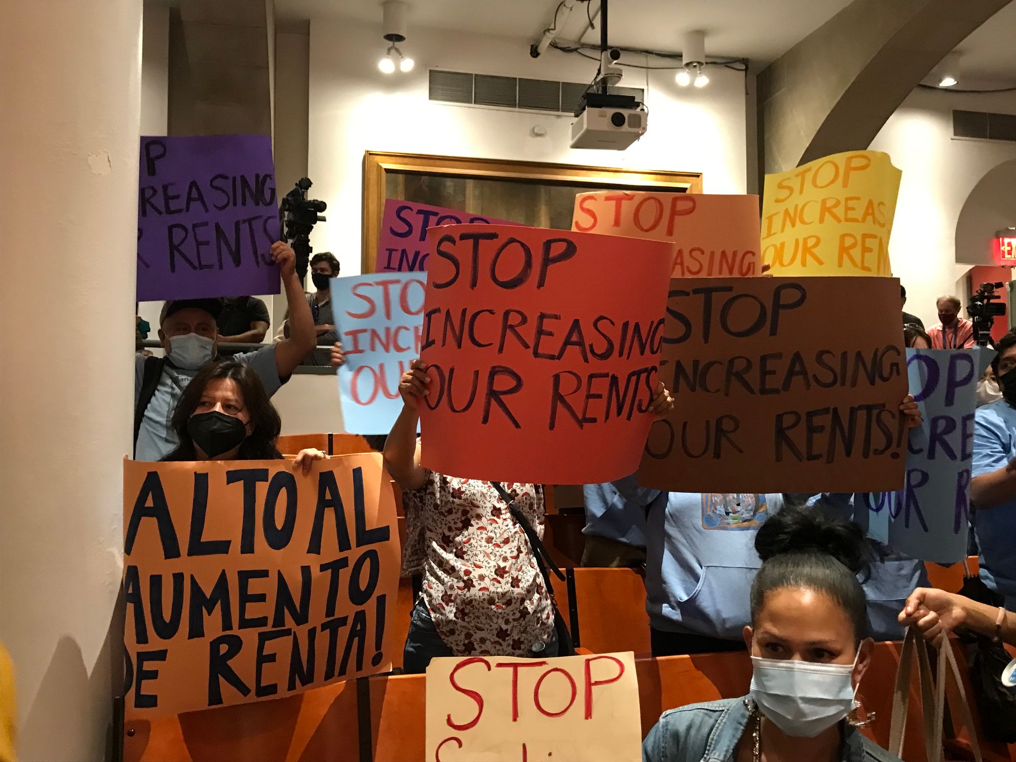 Tenants hold signs that say "stop increasing our rents" during the RGB vote on Tuesday night.