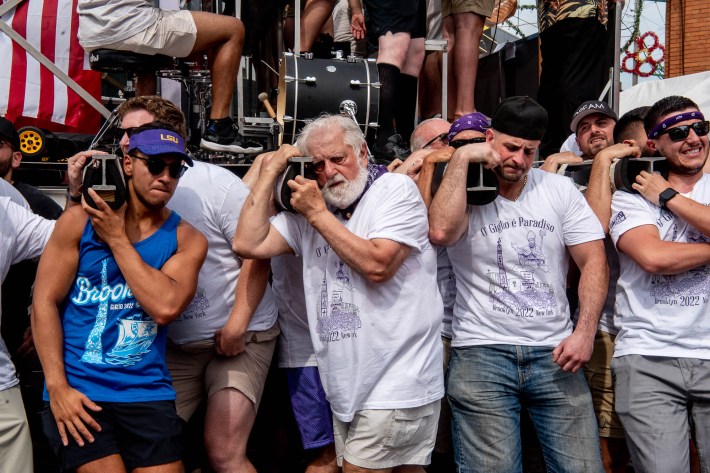 A group of men strain to lift the Giglio