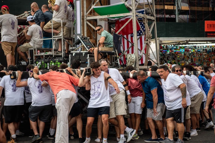 A large group of men lift the Giglio