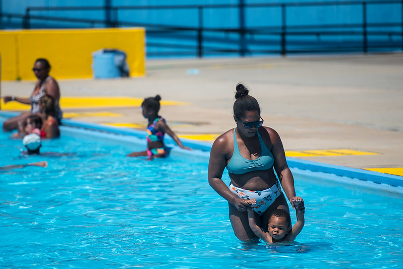 A woman and a small child swim in a city pool