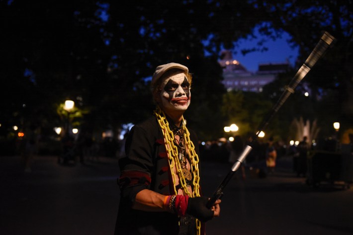 A man wearing Joker make-up, who goes by Joker, in the park at night time looking at the camera.