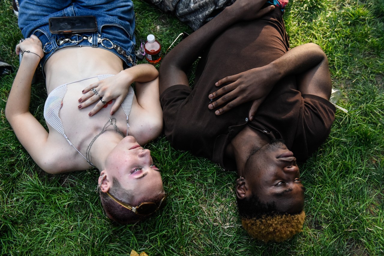 Two people lay in the grass.