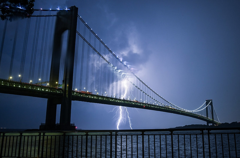 The Verrazzano Bridge at night, a bolt of lightning behind it