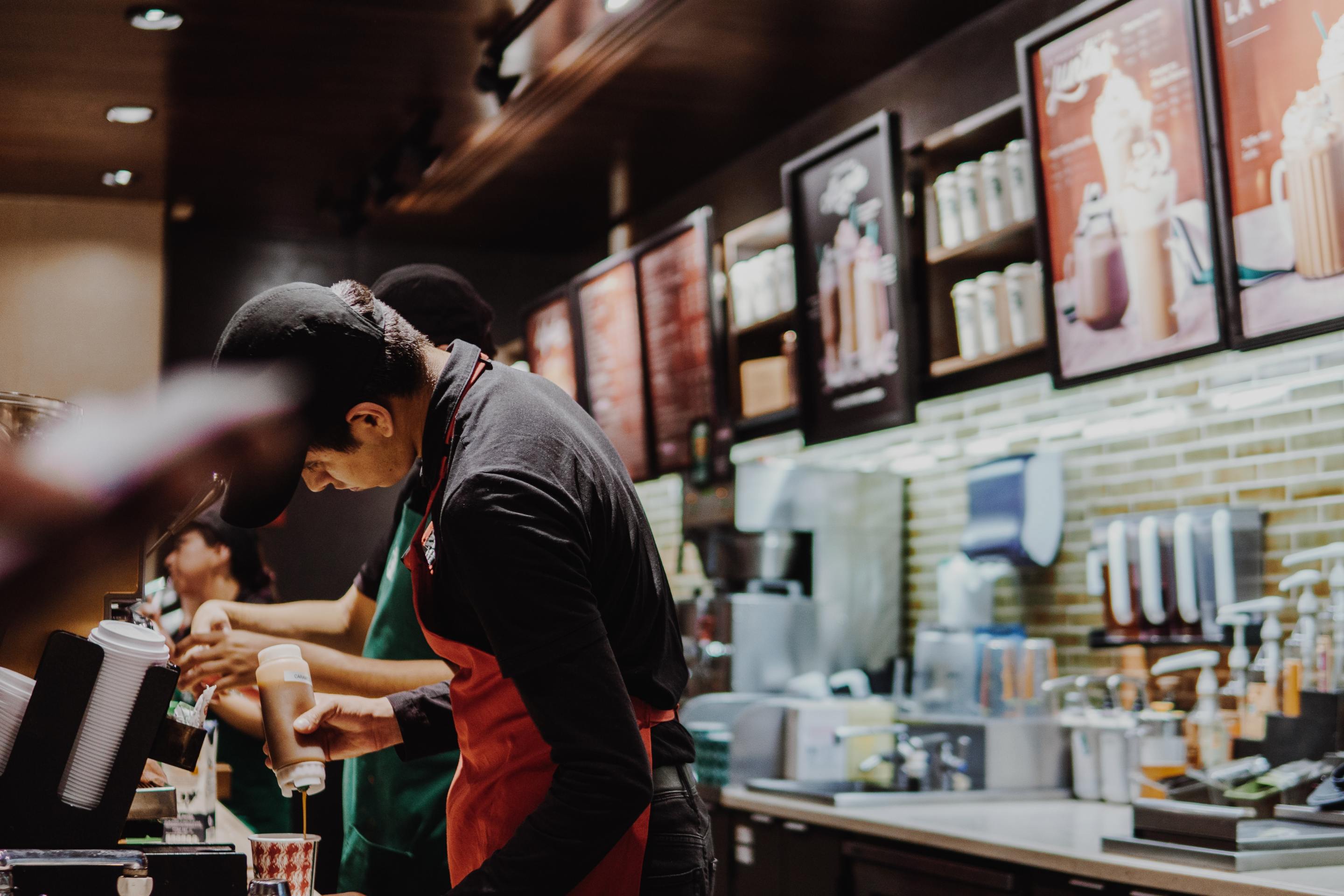 Two baristas work behind the counter at Starbucks