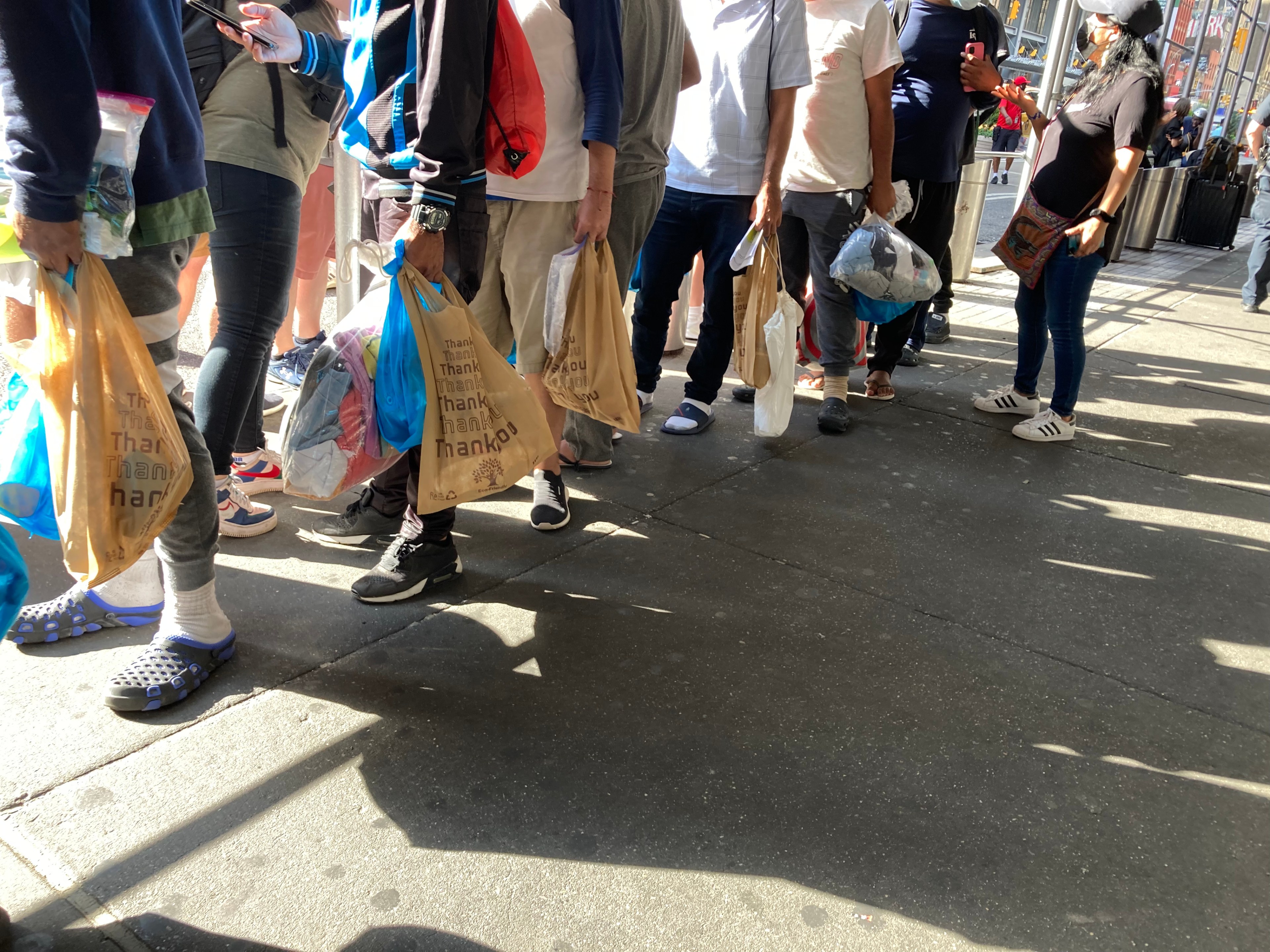 Asylum seekers line up for assistance outside of the Port Authority Bus Terminal on August 10, 2022.