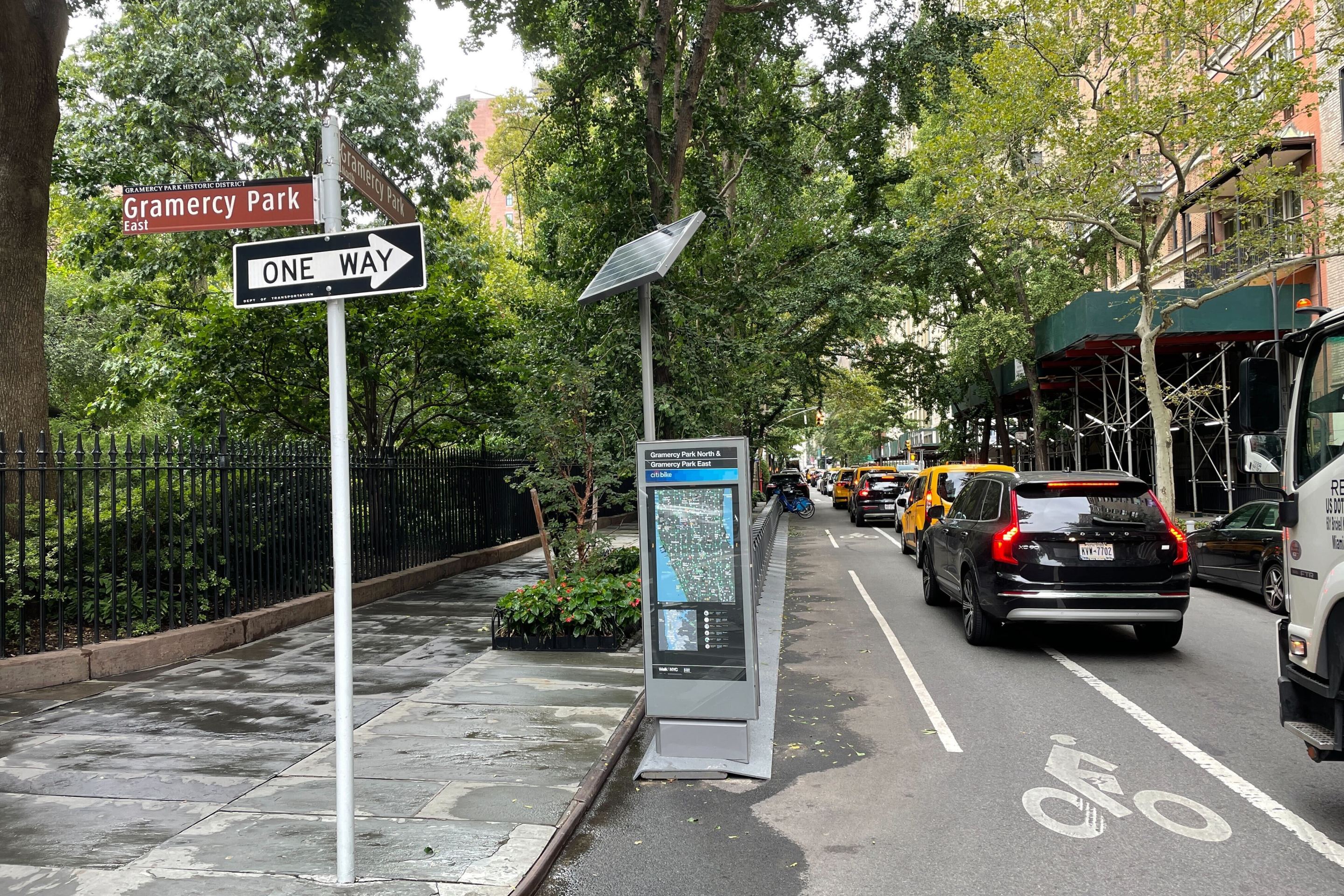 A view looking West on 21st Street, with Gramercy Park on the far left, and the Citi Bike rack sitting on 21st Street, with traffic in the bike lane.