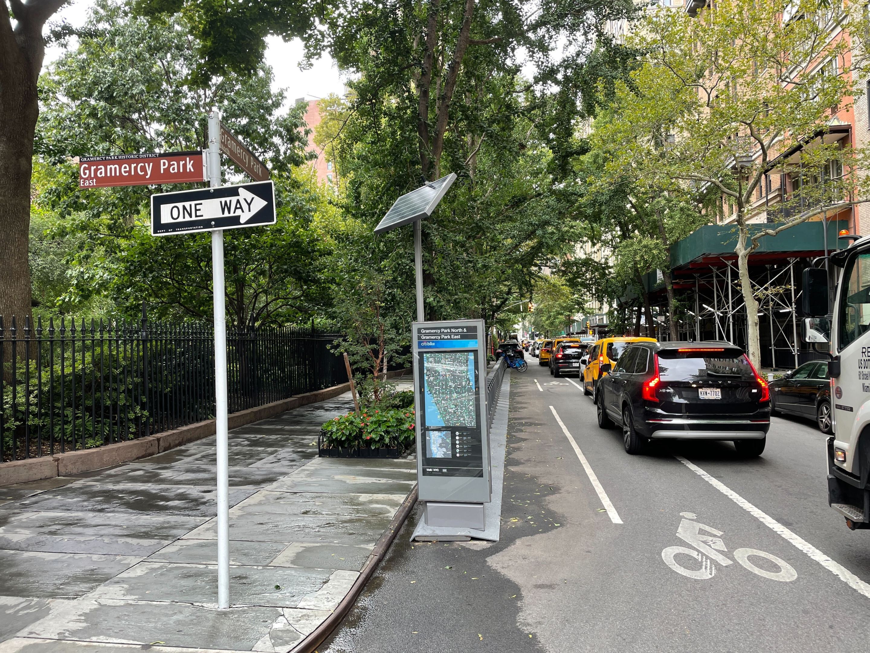 A view looking West on 21st Street, with Gramercy Park on the far left, and the Citi Bike rack sitting on 21st Street, with traffic in the bike lane.