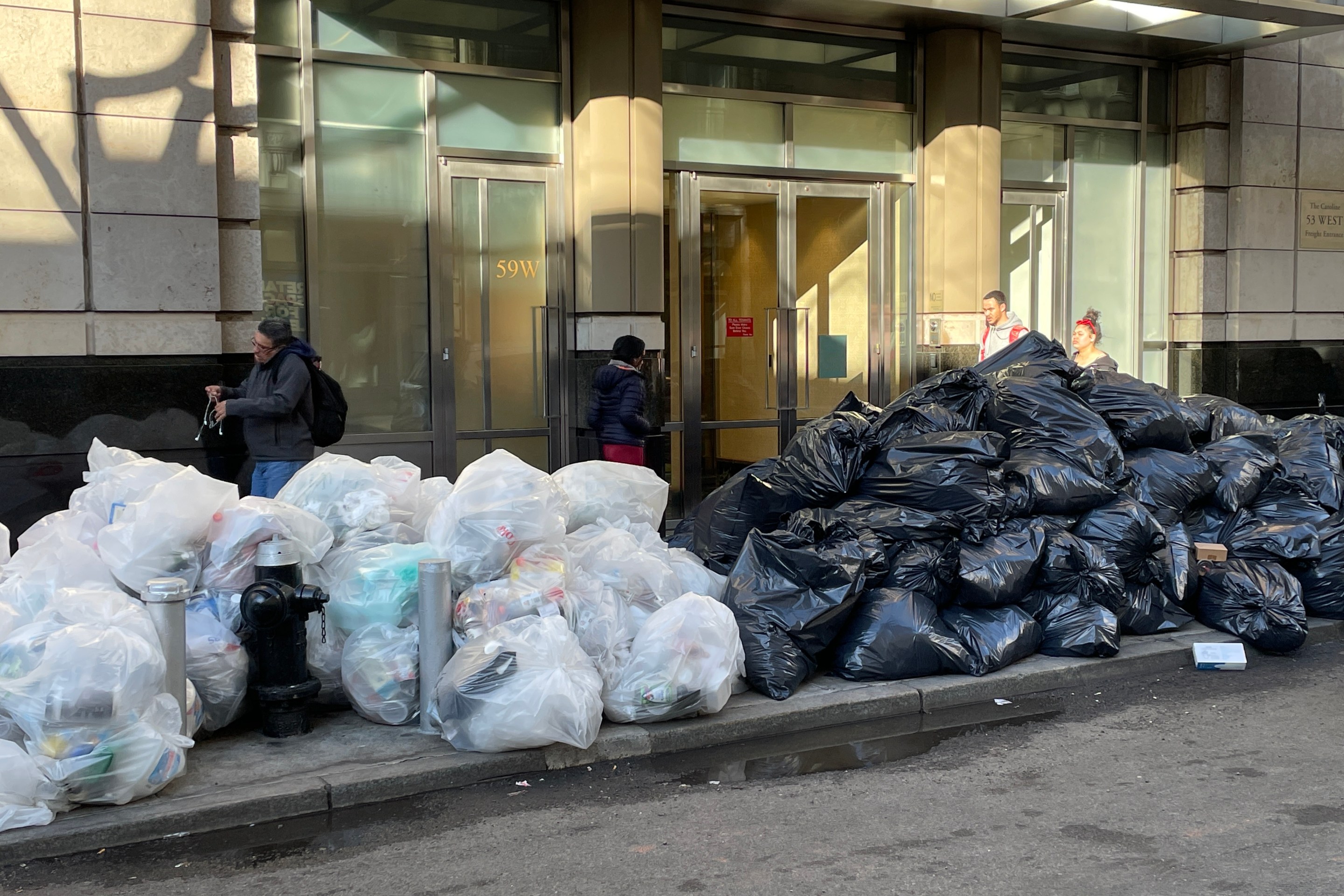 Mountains of trash pile up outside a residential building in Manhattan.