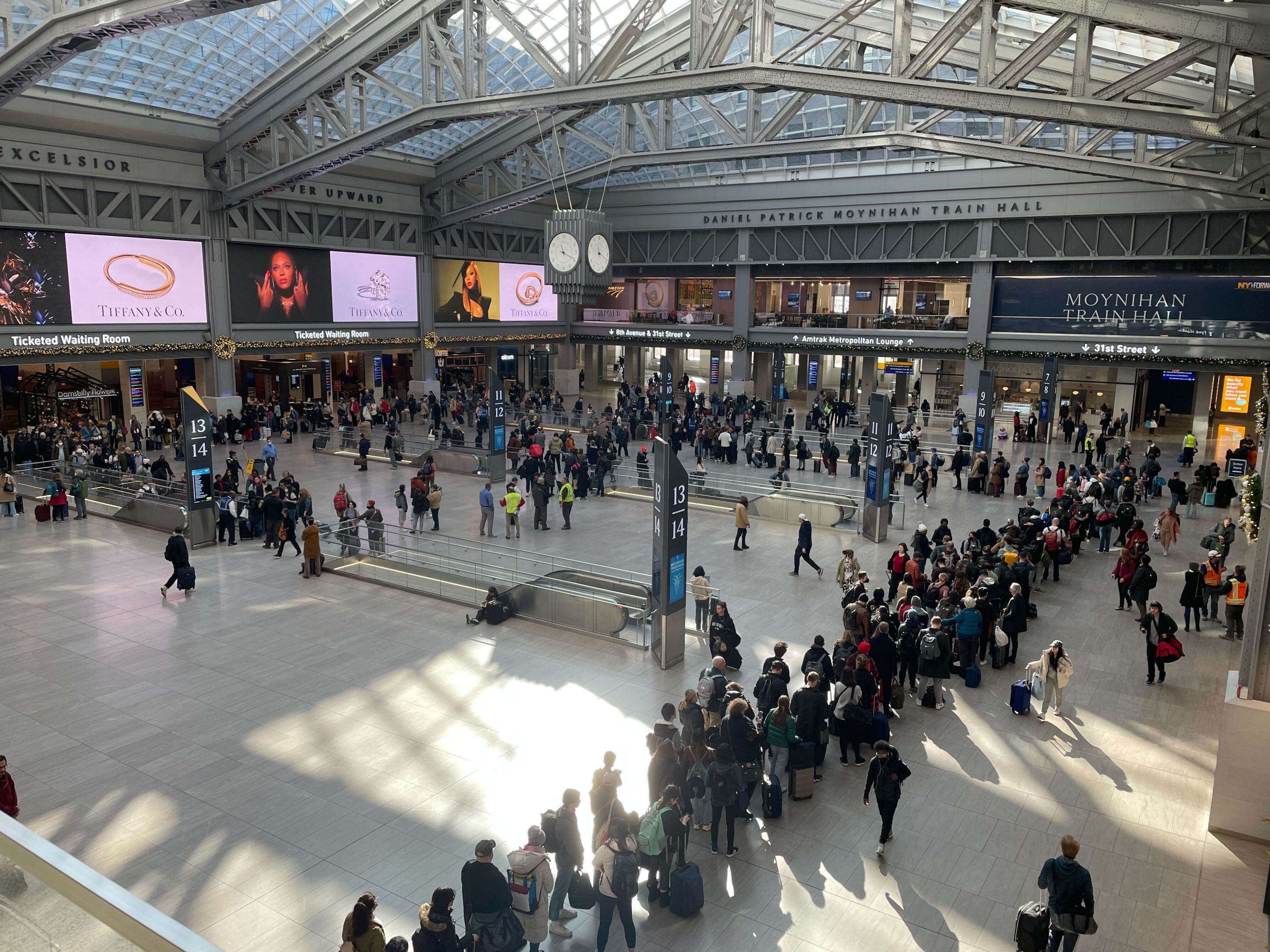 Lines of people of snake around Moynihan Train Hall in an aerial view of the station.