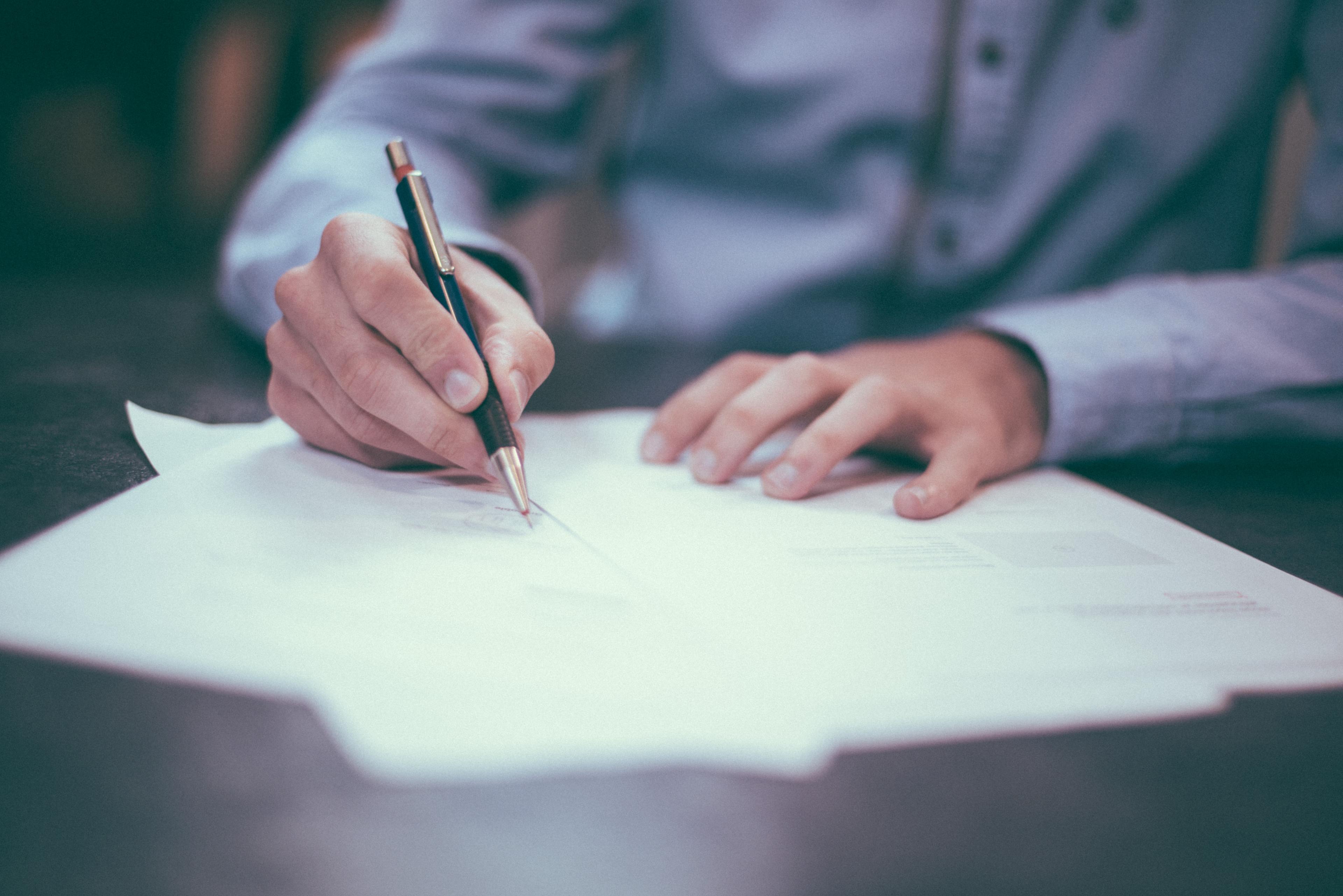 A person signs job application papers.