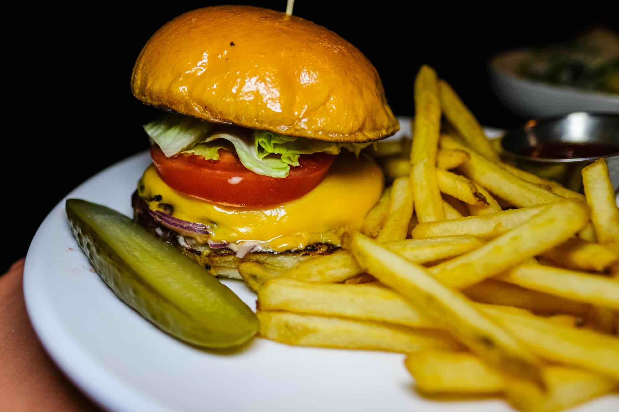 A closeup photo of the The Three Maples burger with fries, $15,