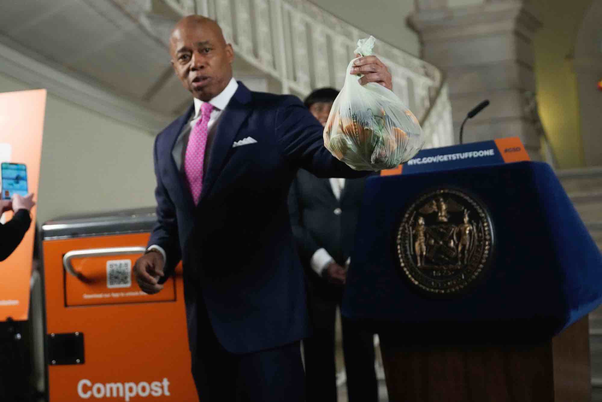 Mayor Adams holds a bag of compost before he tosses it into a new NYC Composting bin at City Hall.