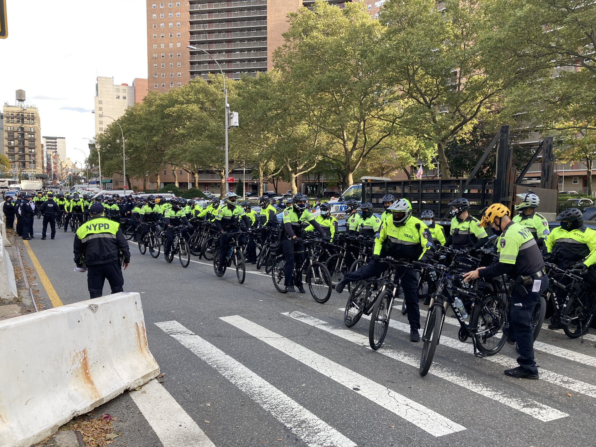 Members of the neon-clad SRG on bicycles behind 1 Police Plaza.