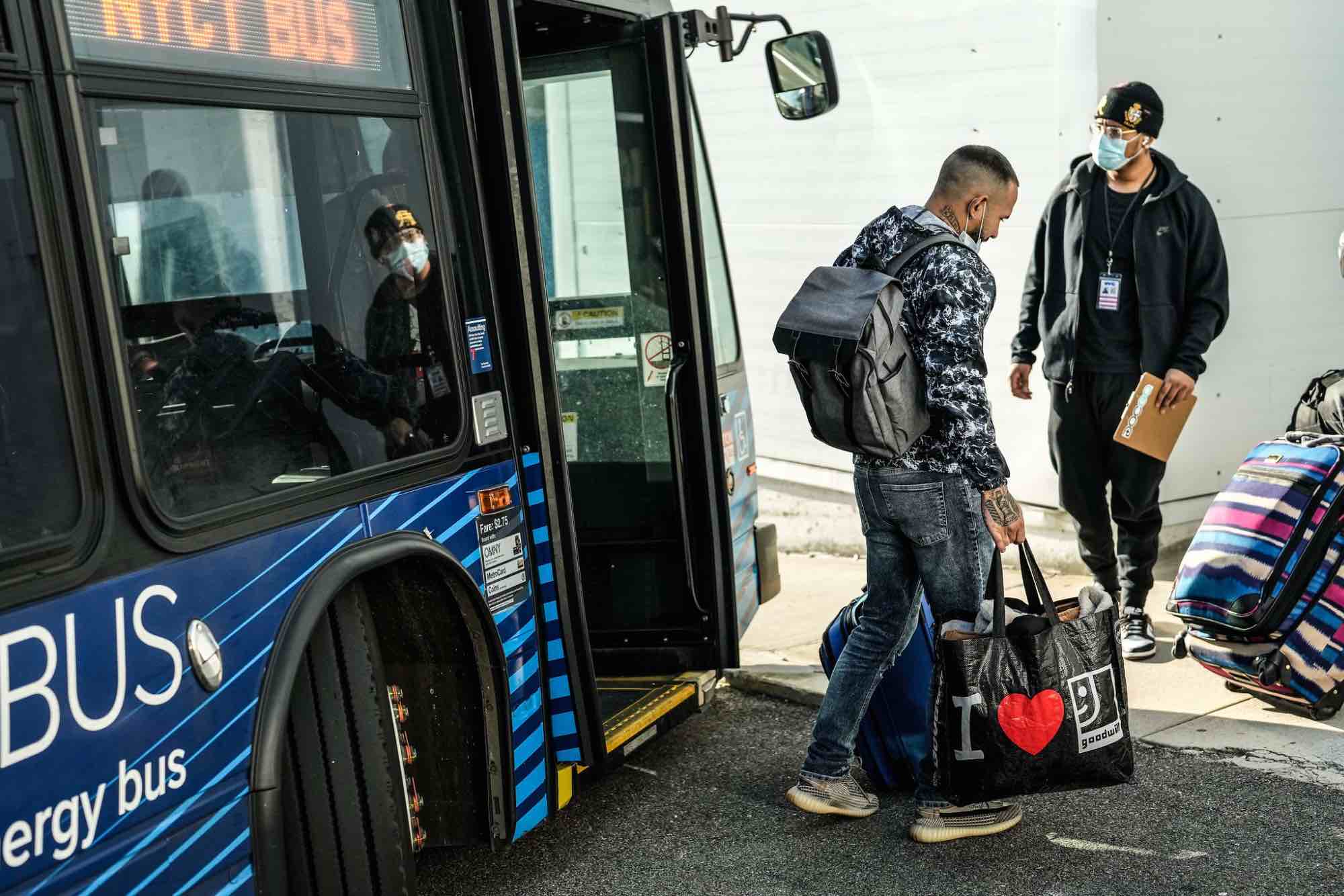 An asylum seeker walks off a bus and into the Brooklyn Cruise Terminal in January.