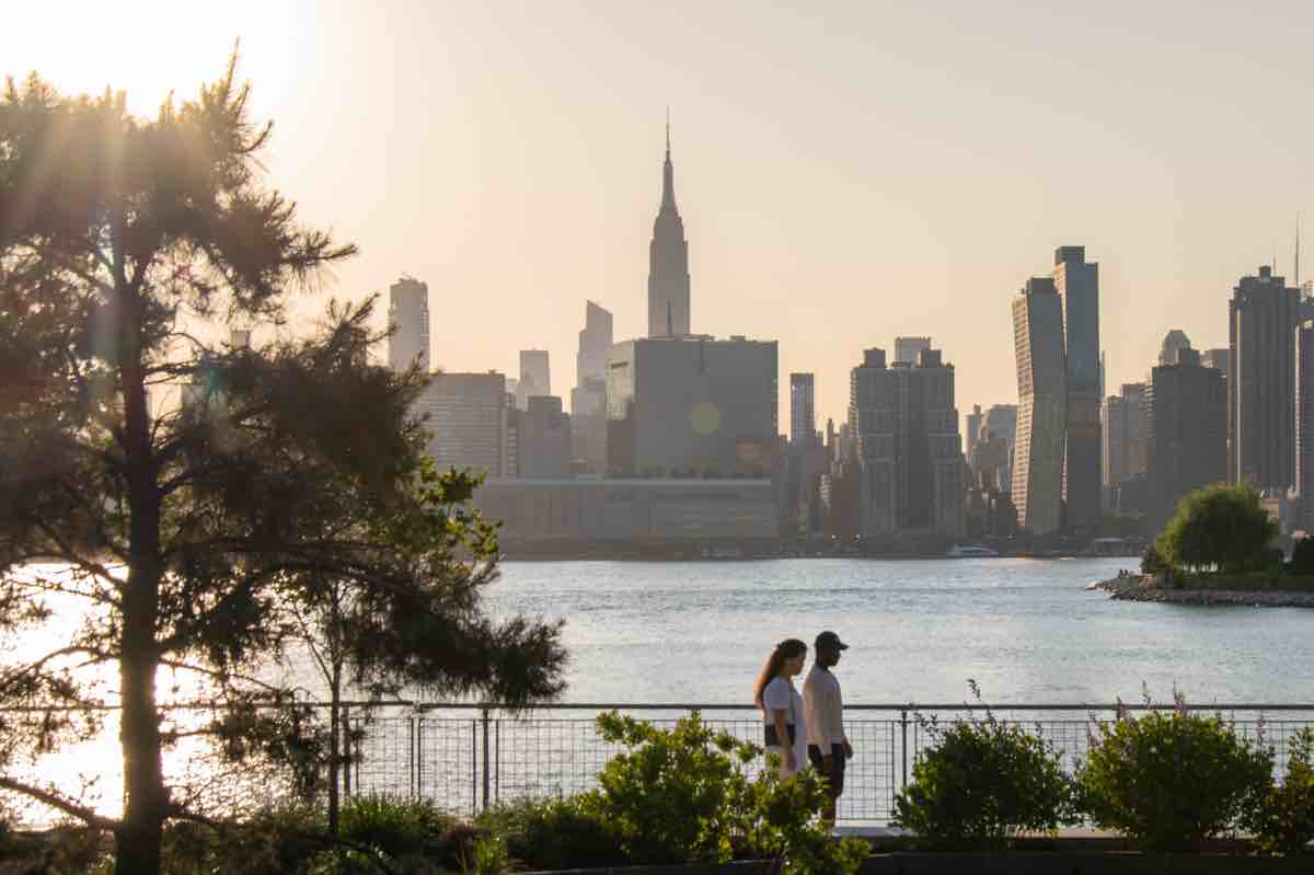 A couple strolls in Brooklyn Bridge Park.
