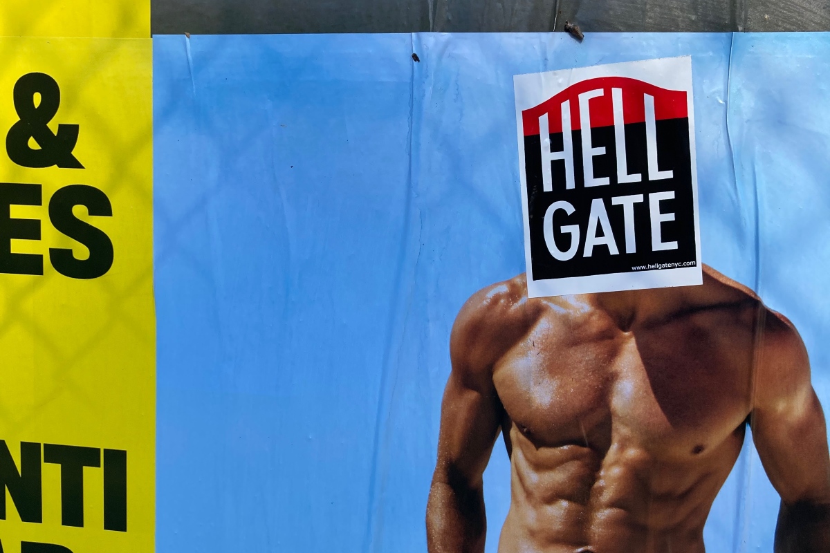 A Hell Gate sticker covering the head of a very muscular, shirtless person.