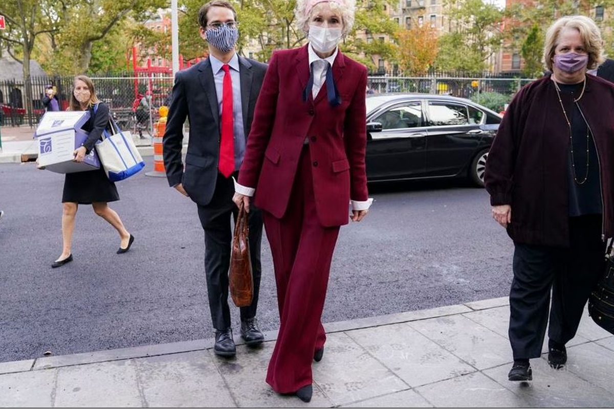 E. Jean Carroll in a burgundy suit on a Manhattan sidewalk.