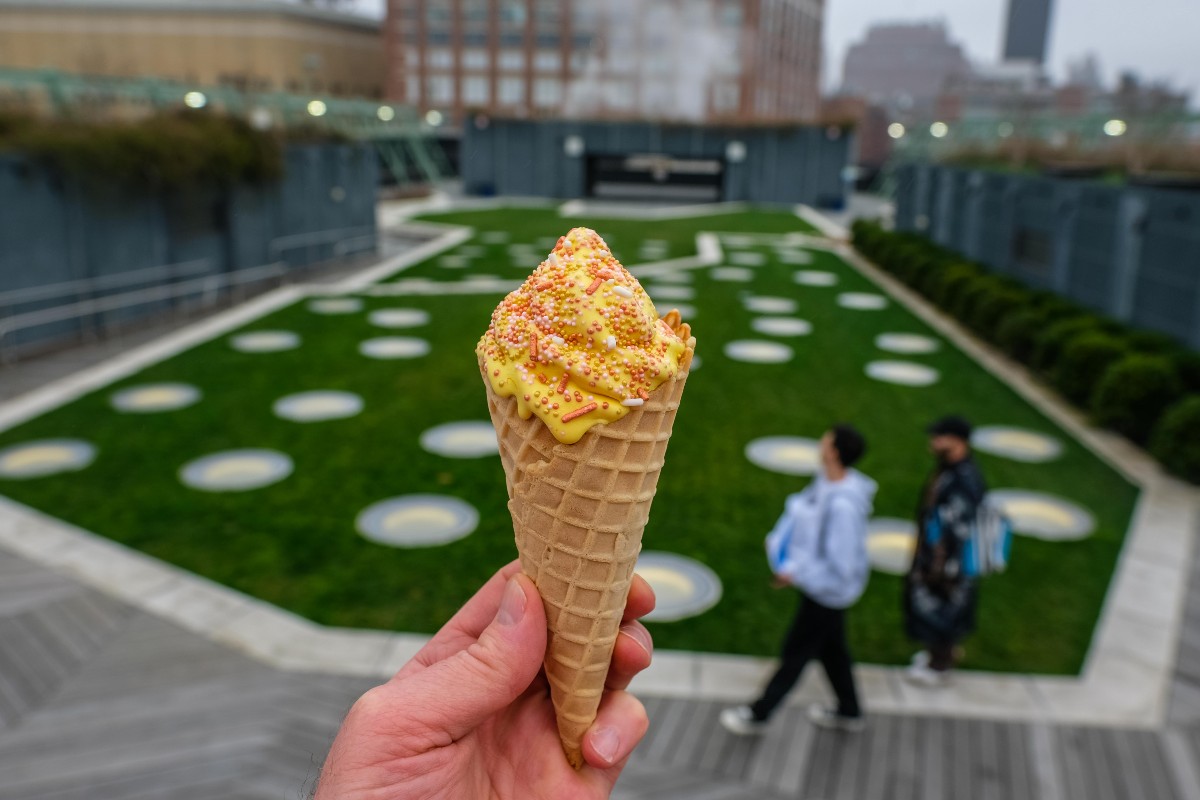Saffron soft serve from Malai held up in front of one of the green spaces on Pier 57 in Chelsea.
