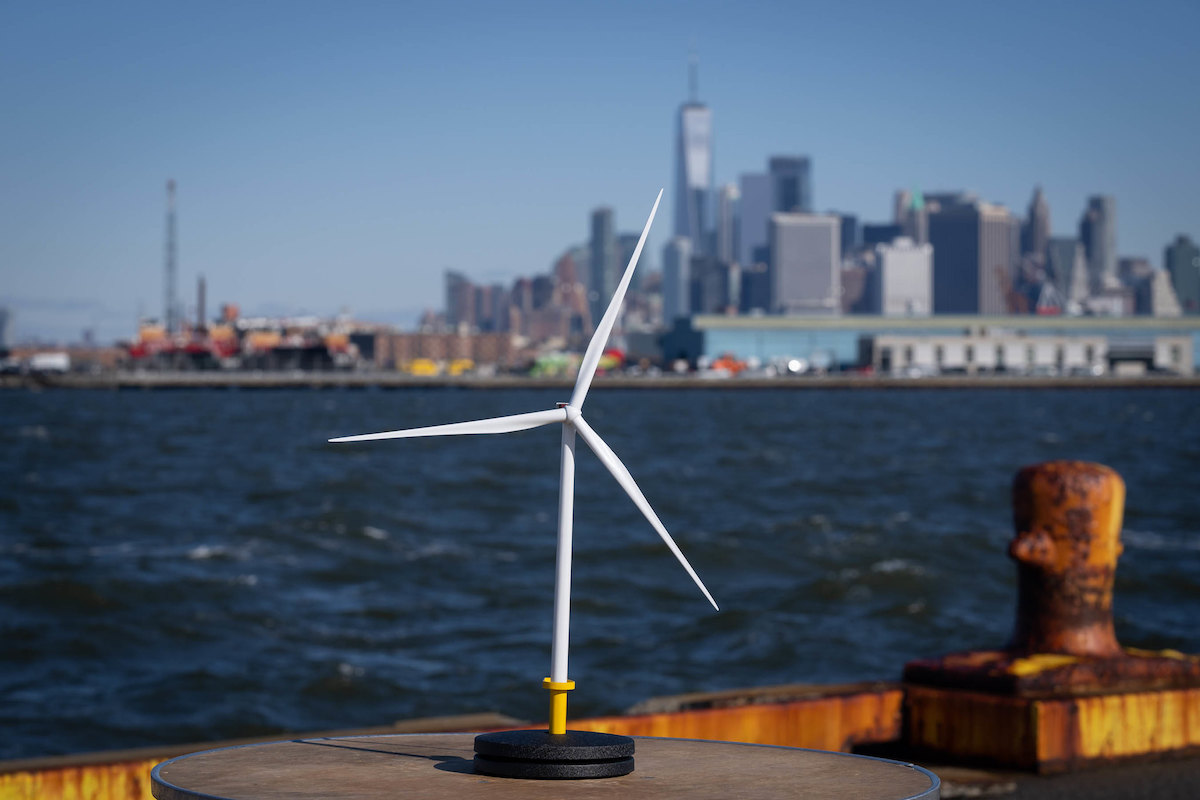 A wind turbine, with New York Harbor in the background.