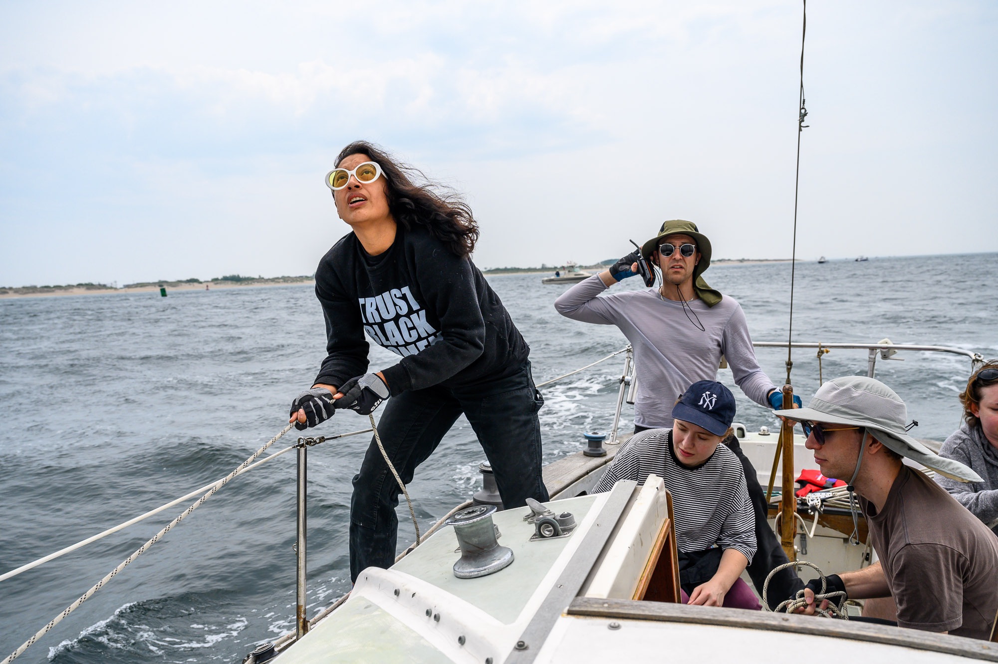 Members of the yacht collective yank pulleys and use walkie-talkies.