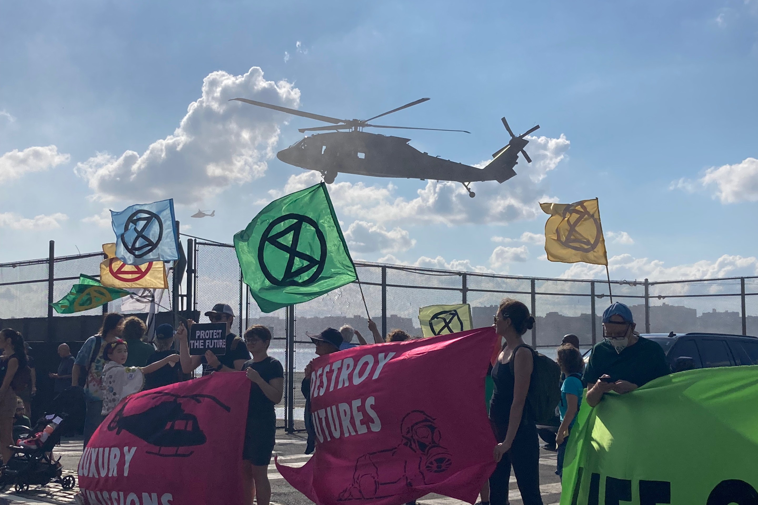 Protesters' banners flap in the prop-wash of a helicopter.