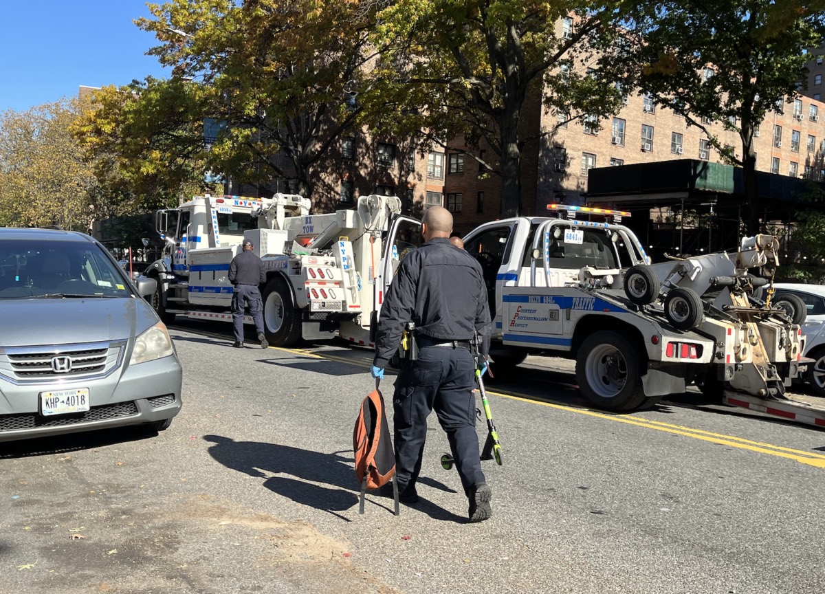 An NYPD officer removes the boy's scooter and backpack from the scene.