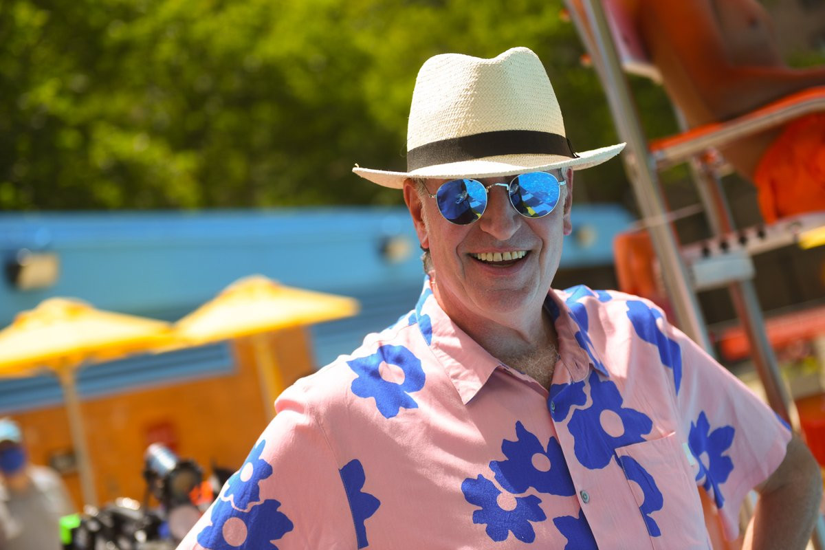 Bill de Blasio in a brimmed hat and reflective sunglasses and pink and blue floral shirt