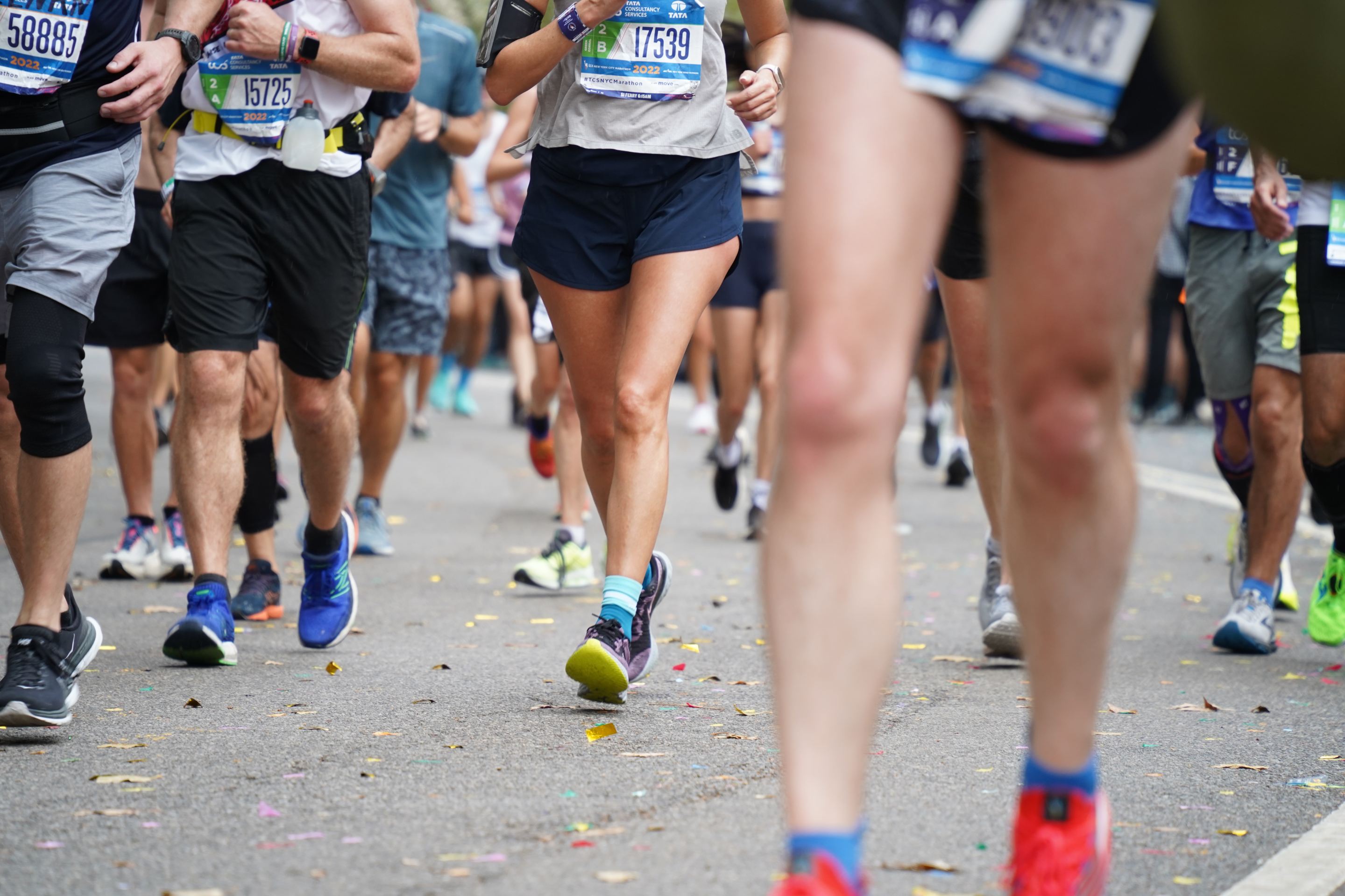 A photo of the torsos and legs of dozens of people running the NYC Marathon.