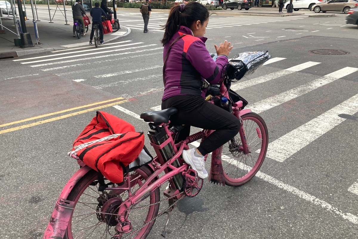 A delivery driver in NYC checks her phone