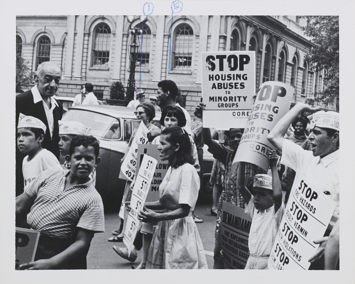 Civil rights protesters with the Congress of Racial Equality hold up signs that say "Stop housing abuses to minority groups" in Lower Manhattan in 1963.