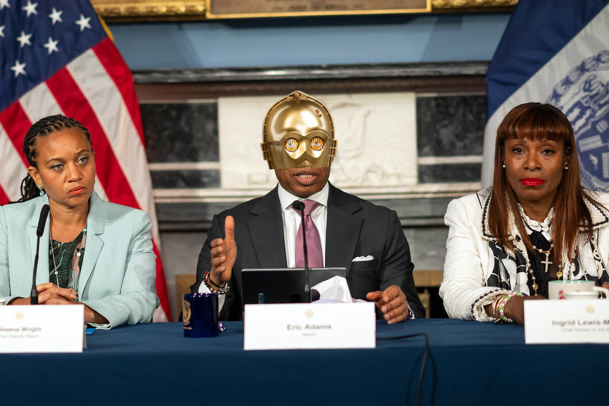 Eric Adams at a press conference with C-3PO's head atop his face.