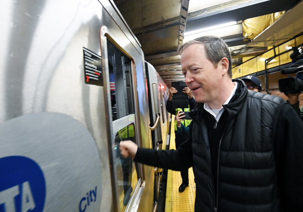Richard Davey taps the subway conductor's window on a train.
